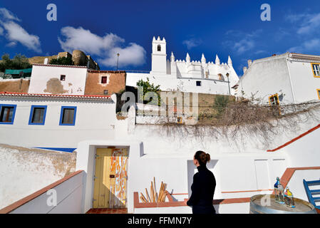 Portugal, Alentejo: Frau Blick von Terrasse auf Kirche und Burg des historischen Dorfes Mértola Stockfoto
