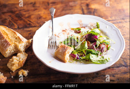 Rucola-Salat auf weißem Porzellanteller mit Brusheta Brot Stockfoto