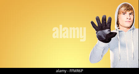 Zusammengesetztes Bild des Mannes mit schwarzen Handschuhen in die Kamera starrt Stockfoto