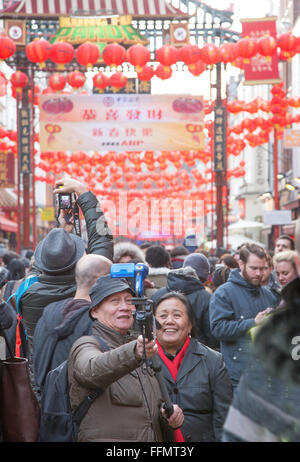 Chinesisches Ehepaar nehmen Selfie am chinesischen Neujahrsfest in Gerrard St London W1 Stockfoto