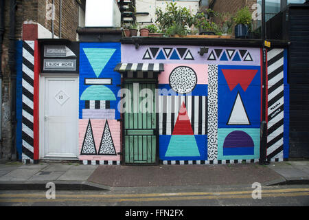 Shoreditch & Hoxton Bereich street-Art, London. Eine Gebäudehülle mit einem bunten geometrischen Wandbild gemalt. Stockfoto