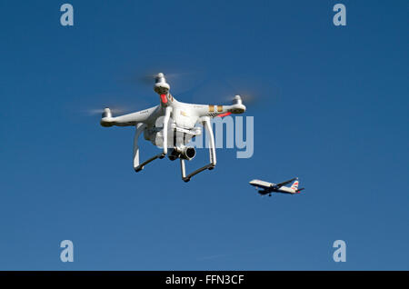 Eine DJI Phantom 3 Professional Quadcopter (oft eine Drohne genannt) mit einem BA-Flugzeug vorbei hinter. Stockfoto