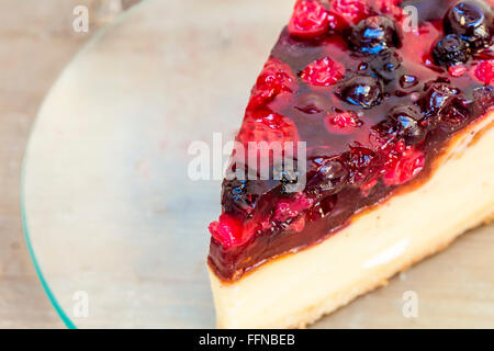 Käsekuchen mit Erdbeeren in einer Platte auf einem Holztisch Stockfoto