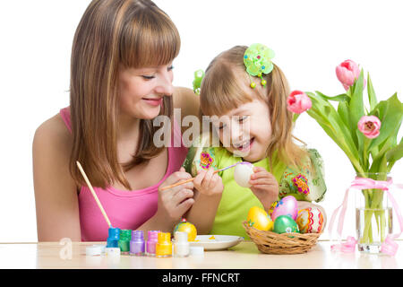 glückliche Mutter und Kind Tochter Vorbereitung auf Ostern und mit Pinsel Färbung Eiern Stockfoto