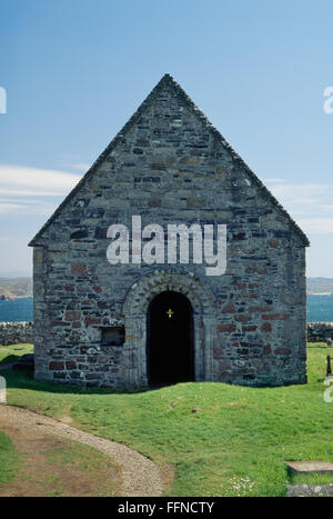 Mittelalterliche Kapelle & Beerdigung Boden gewidmet St. Columba Cousin St Oran, SW der Iona Abbey, Argyll. Romanische (C12th, Irisch) Tür & Metallkreuz. Stockfoto