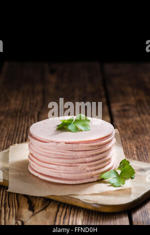 Mortadella (Tiefenschärfe) in Scheiben geschnitten auf Vintage Holz-Hintergrund (close-up erschossen) Stockfoto