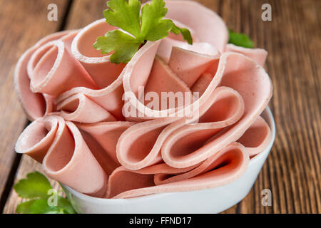 Mortadella (Tiefenschärfe) in Scheiben geschnitten auf Vintage Holz-Hintergrund (close-up erschossen) Stockfoto