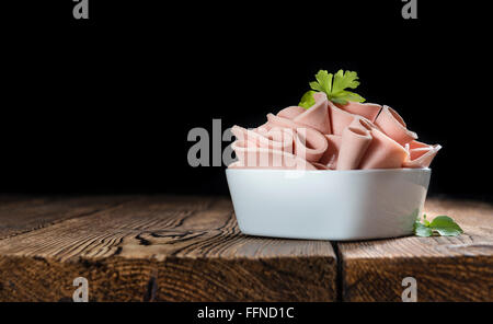 Mortadella (Tiefenschärfe) in Scheiben geschnitten auf Vintage Holz-Hintergrund (close-up erschossen) Stockfoto