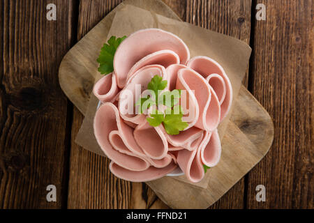 Mortadella (Tiefenschärfe) in Scheiben geschnitten auf Vintage Holz-Hintergrund (close-up erschossen) Stockfoto