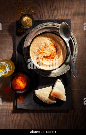 Hummus mit Paprika, Kreuzkümmel, Olivenöl und Brot Stockfoto