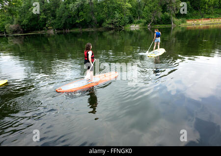 Teen Frauen am Stand up Paddleboards durchqueren Kanal zwischen Lake Calhoun und See der Inseln. Minneapolis Minnesota MN USA Stockfoto