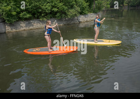 Teenager Frauen auf Paddleboards zwischen Lake Calhoun und See der Inseln mit Rettungswesten paddeln. Minneapolis Minnesota MN USA Stockfoto