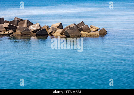 Massivem Stein und Staumauer am Meer Stockfoto