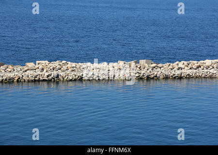 Massivem Stein und Staumauer am Meer Stockfoto