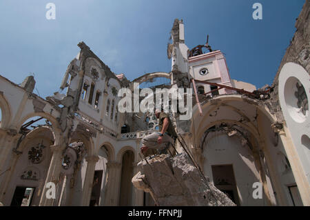 Einav Abgabe delegation Manager von Natan Internationale Humanitäre Hilfe sitzen über Reste der Kathedrale Unserer Lieben Frau von der Himmelfahrt in Port-au-Prince nach einem Erdbeben der Stärke 7.0 in Haiti am 12. Januar 2010 schlug Stockfoto