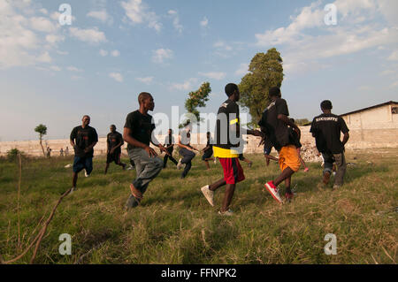 Einav Abgabe delegation Manager von Natan Internationale Humanitäre Hilfe, die an einer körperlichen Übung mit einer Gruppe von haitianischen Männer geschultes Sicherheitspersonal der behelfsmäßigen Lager für Überlebende einer Stärke von 7,0 Erdbeben, das Haiti am 12. Januar 2010 Am Stadtrand von Port-au-Prince gefunden werden Stockfoto