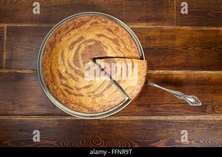 Zebra-Kuchen von oben über hölzerne Hintergrund mit Spachtel Stockfoto