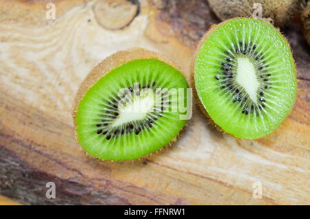 Saftige halbierten Kiwi auf einem rustikalen Holzbrett Stockfoto