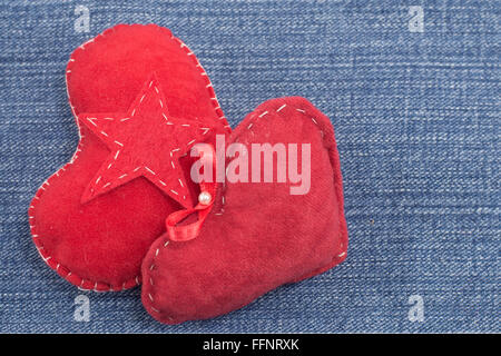 zwei rote Herzen und ein Stern auf Denim Hintergrund Stockfoto