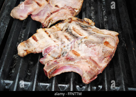 Nahaufnahme von einem saftigen Porkchop Kochen auf dem Grill Stockfoto