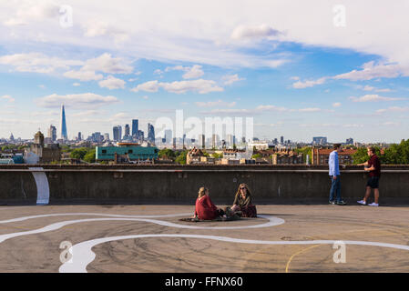 Zwei Mädchen und zwei Jungs Bier trinken auf dem Boden der Franken Cafe Bar auf der Dachterrasse Café in Peckham, kühl und im Südosten von London Stockfoto