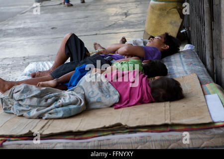 Innerhalb der philippinischen Städte ersichtlich auf Bürgersteigen schlafen obdachlose Menschen, darunter Kinder & ganze Familien. Stockfoto