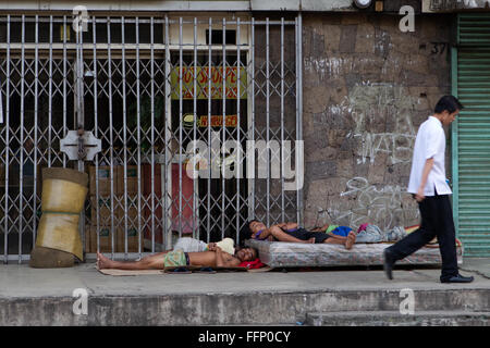 Innerhalb der philippinischen Städte ersichtlich auf Bürgersteigen schlafen obdachlose Menschen, darunter Kinder & ganze Familien. Stockfoto