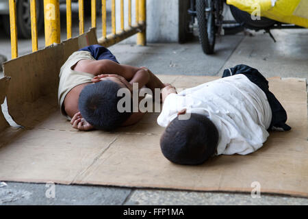 Innerhalb der philippinischen Städte ersichtlich auf Bürgersteigen schlafen obdachlose Menschen, darunter Kinder & ganze Familien. Stockfoto