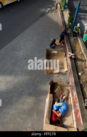 Innerhalb der philippinischen Städte ersichtlich auf Bürgersteigen schlafen obdachlose Menschen, darunter Kinder & ganze Familien. Stockfoto