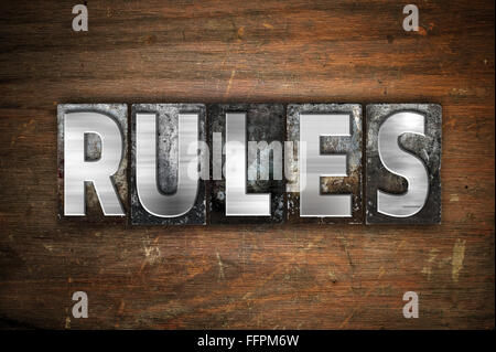 Das Wort "Regeln" in Vintage Metall Buchdruck Typ auf einem alten hölzernen Hintergrund geschrieben. Stockfoto