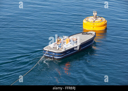 Ajaccio, Frankreich - 30. Juni 2015: Hafenbetrieb, Männer bei der Arbeit. Motorboot ist für Seil Verbindung auf gelben Anlegeboje verwendet. Stockfoto