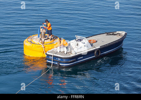 Ajaccio, Frankreich - 30. Juni 2015: Hafenbetrieb, Männer bei der Arbeit. Motorboot ist für Seilbefestigung an der Boje festmachen verwendet. Stockfoto