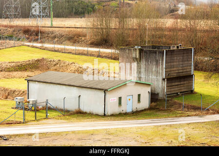 Kallinge, Schweden - 7. Februar 2016: Eine konkrete Ruine ungenutzt bleibt in einem Industriegebiet in einem eingezäunten Platz. EON-logo Stockfoto