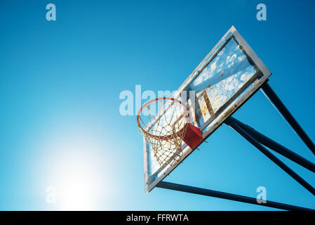 Plexiglas-Straße Basketball Board mit dem Reifen auf Freiplatz gegen blauen sonnigen Himmel als Textfreiraum. Stockfoto