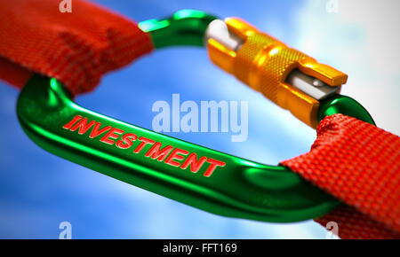Investition auf grünen Karabiner zwischen roten Seilen. Stockfoto