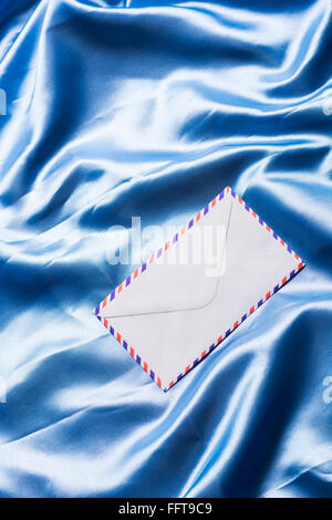 Luftpost Umschlag über blaue Seide Stockfoto