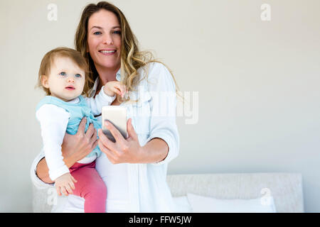 lächelnde Frau, die eine Selfie mit einem baby Stockfoto