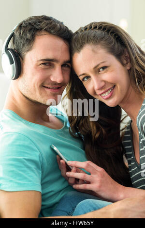 Junges Paar anhören von Musik auf dem Handy Stockfoto