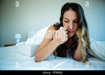 Frau im Bett suchen verärgert Stockfoto