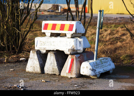 Einen kleinen Stapel von konkreten Straßensperren und einem Verkehrsunfall unterzeichnen am Straßenrand in einem Industriegebiet. Stockfoto