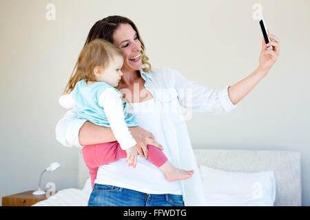 lächelnde Frau, die eine Selfie mit einem baby Stockfoto
