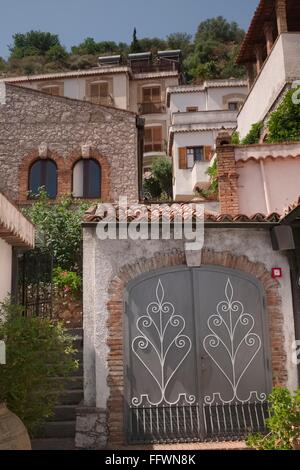 Gestaffelte Häuser gebaut am steilen Hang von Taormina. Das griechische Theater ist nur über den Hügel Kamm Stockfoto