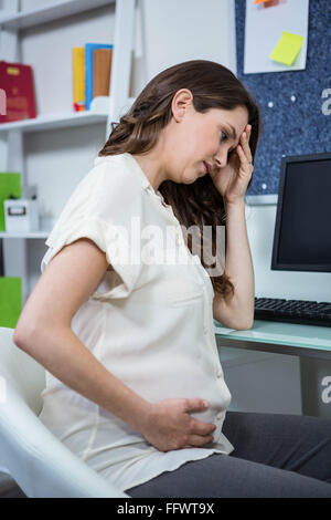 Schwangere Frau mit Kopfschmerzen Stockfoto