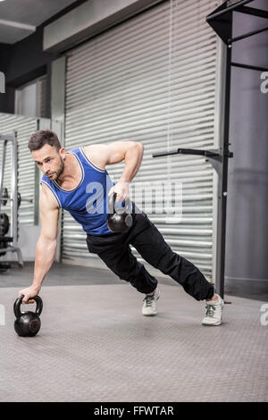 Muskulöser Mann tun Push up mit kettlebells Stockfoto