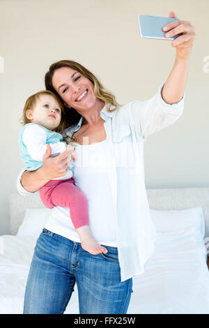 Lächelnde Frau, die eine Selfie mit ihrem baby Stockfoto