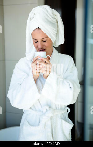 Frau in einen Morgenmantel, trinken eine Tasse Kaffee Stockfoto