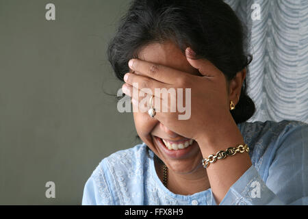 Südasiatische indische Junge Dame lächelt und versucht sich zu verstecken ihr Gesicht Herr #643 Stockfoto