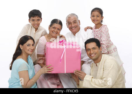 Eltern mit Kindern halten Geschenkbox und verleihen Großeltern Herr #703N, 703O, 703P, 703Q, 703R, 703S Stockfoto
