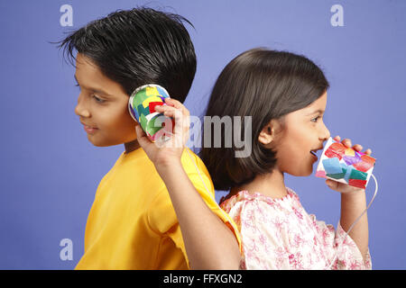 Zehn und acht Jahr machte alten Jungen und Mädchen des Kindes Telefonat Empfänger von zwei Gläsern und Draht Herr #703U 703V Stockfoto