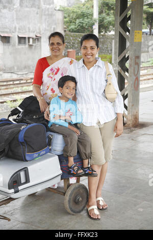 Großmutter und Mutter mit Sohn sitzen auf Gepäck Stand gehalten auf Wagen Herr #468 Stockfoto